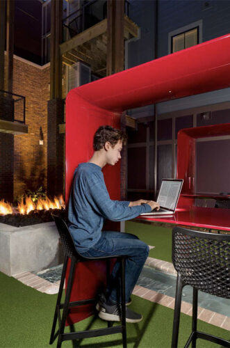 Resident enjoying the outdoor lounge while working on a computer